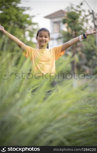 asian teenager hand sign victory in green garden