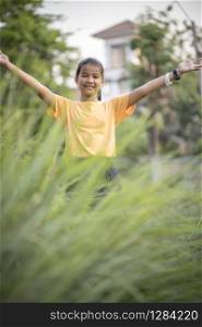 asian teenager hand sign victory in green garden