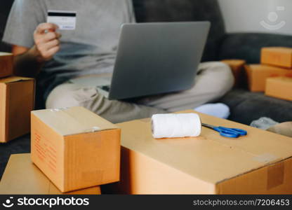 Asian teenager holds a credit card and is using a laptop computer shopping online concept.