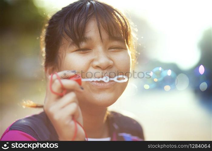 asian teenager relaxing with soup bubble against beautiful sun light