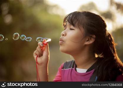 asian teenager relaxing with soup bubble against beautiful sun light