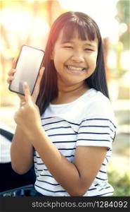 asian teenager show white screen of smart phone screen and toothy smiling face happiness emotion