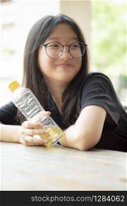 asian teenager smiling face holding pastic bottle in hand