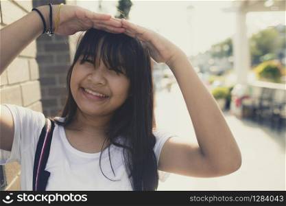 asian teenager toothy smiling face with happiness emotion against beautiful sun light background