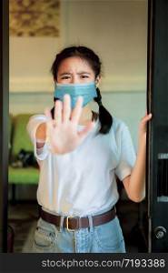 asian teenager wearing protection mask standing with hand sign do not closer