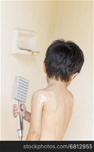 Asian Thai little boy in a bath room taking a good shower at home