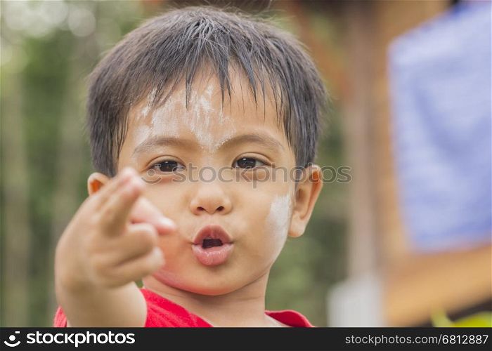 Asian Thai little boy making gun gesture with finger