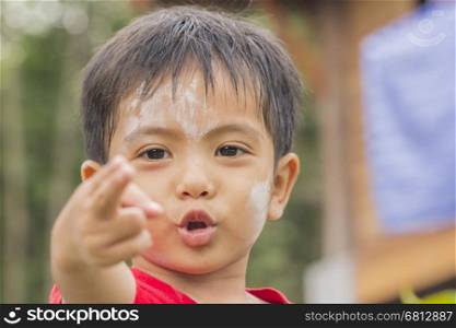 Asian Thai little boy making gun gesture with finger