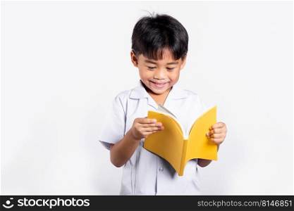 Asian toddler smile happy wearing student thai uniform red pants standing holding and reading a book in studio shot isolated on white background, Portrait little children boy preschool, Back to school