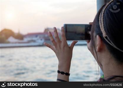 asian tourism take photo with mobile phone to capture moment in destination of Bangkok ,Thailand