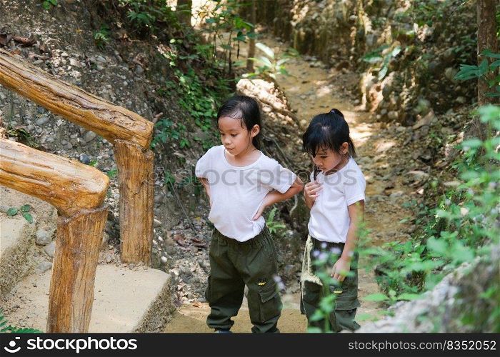 Asian tourist family, two sisters rest while traveling to Pha Chor is high soil canyon cliffs at Mae Wang National parks in Chiang Mai,Thailand. Travel and lifestyle concepts
