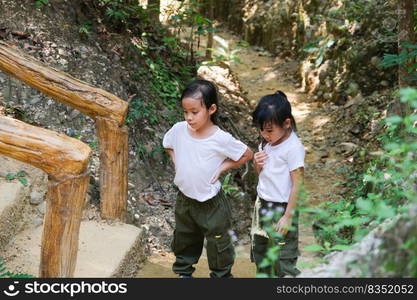 Asian tourist family, two sisters rest while traveling to Pha Chor is high soil canyon cliffs at Mae Wang National parks in Chiang Mai,Thailand. Travel and lifestyle concepts