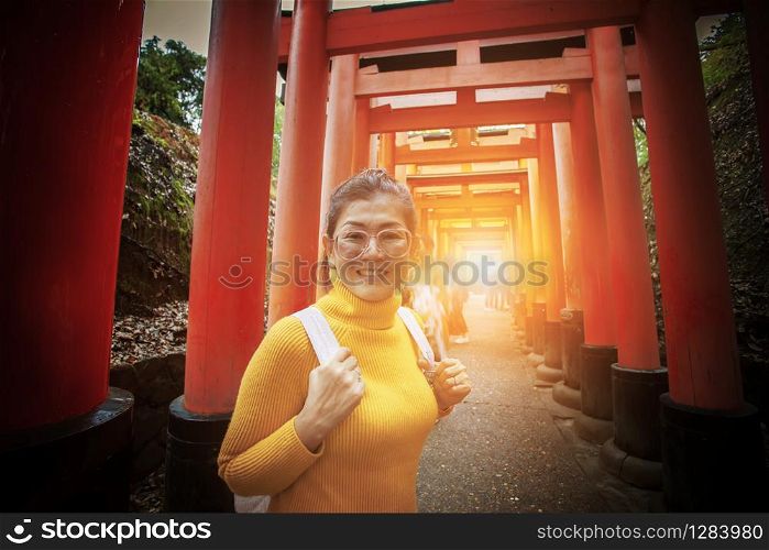 asian tourist toothy smiling face in fushimi inari shrine one of most popular traveling destination in kyoto japan
