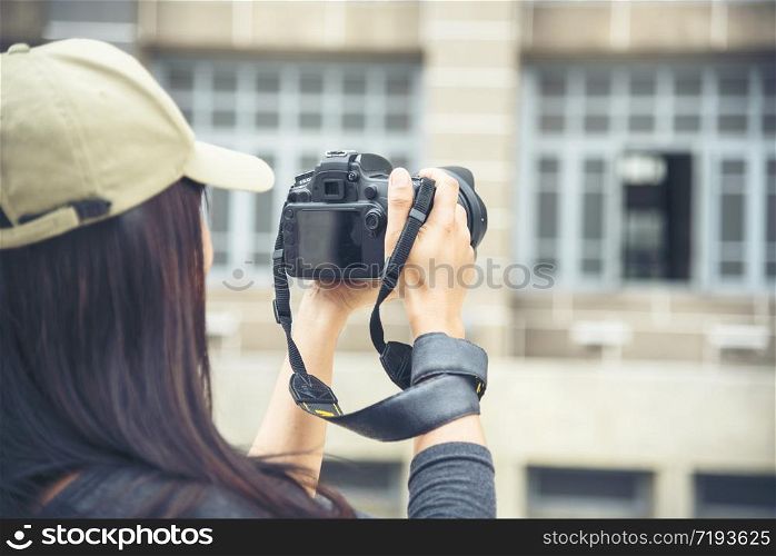 Asian tourist using dslr professional camera travel on vacation. Female young traveler with backpack and photo camera in the old town. Beautiful woman backpack around the word. Young traveller concept