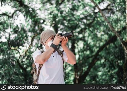 Asian traveler man with backpack taking a photo in the park. Travel photographer. Vocation and holiday concept.