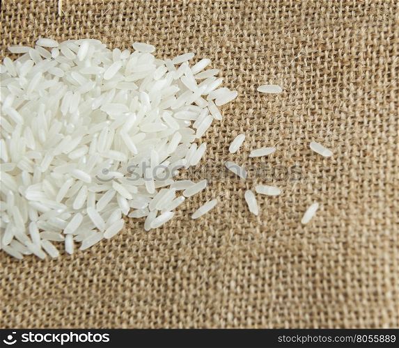 Asian uncooked white rice on a background of rough cloth