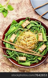 Asian vegetarian salad with seasonal vegetables and spaghetti. Oriental vegetable salad with pasta