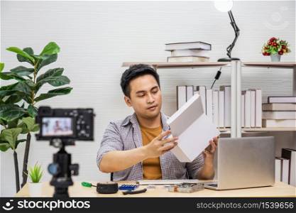 Asian Vlogger man recording Video about unboxing the hard ware and sharing knowledge to audience via camera for social media Live session, taking video and live, vlog and Influencer concept