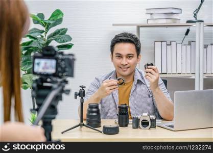 Asian Vlogger man satisfied the camera lens each media, Video Cameraman taking video and live with laptop, sharing knowledge to audience via camera by social media channel,vlog and Influencer concept