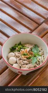 Asian white noodles. Asian white noodles with pork and vegetables in bowl over wooden background
