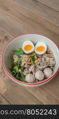 Asian white noodles. Asian white noodles with pork and vegetables in bowl over wooden background