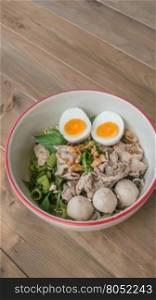 Asian white noodles. Asian white noodles with pork and vegetables in bowl over wooden background