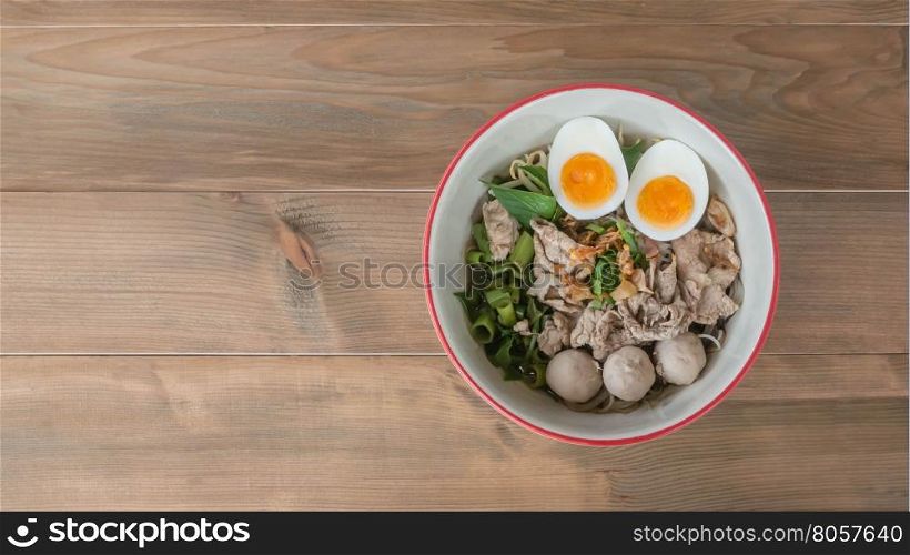 Asian white noodles with pork and vegetables in bowl over wooden background, , Free space for text
