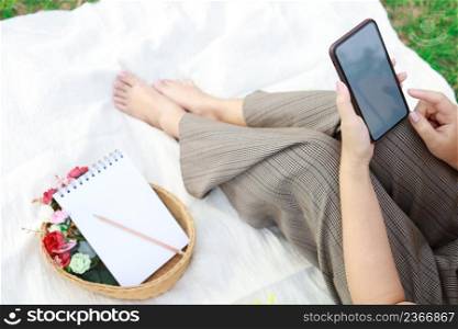 Asian woman alone resting on a picnic in nature park outside at sunny day enjoying summertime and dreaming