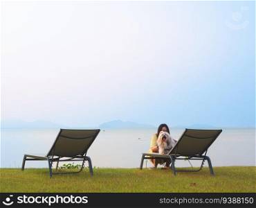 Asian woman and her cute dog enjoy summer day on the beach with relaxing lifestyle