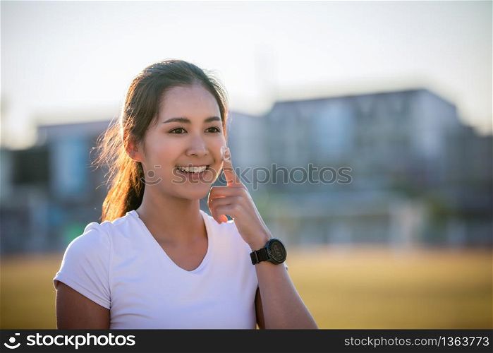 Asian Woman applying and spraying sunscreen cream on skin before run. Sports and healthy concept