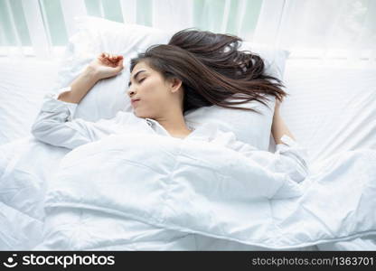 Asian woman Beautiful young smiling woman sitting and sleeping in white bed and stretching in the morning at bedroom after waking up in her bed fully rested