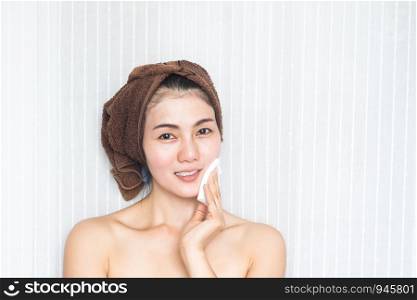 Asian woman cleansing her face. Beauty and skincare concept