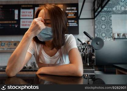 Asian woman coffee shop business owner Stressed and disappointed from The effects of the coronavirus pandemic resulting in business losses