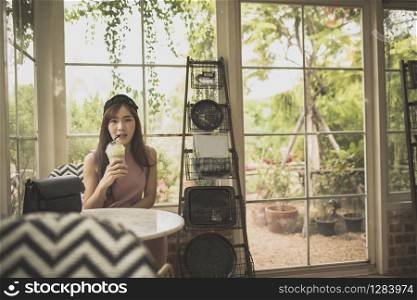 asian woman drinking cool green tea beverage in cafe