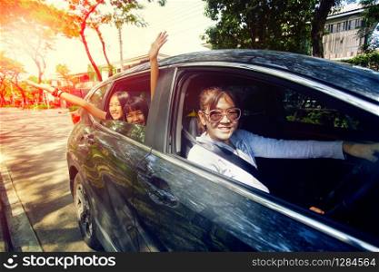 asian woman driving car with happiness teenager in passenger seat