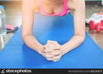 Asian woman elbow planking on blue mat, Front view with sunlight, Healthy lifestyle concept