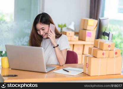 Asian woman enjoy herself while using internet on laptop and phone in office. Business and marketing and part time concept. Online shopping and business success theme. Happy mood doing working job.