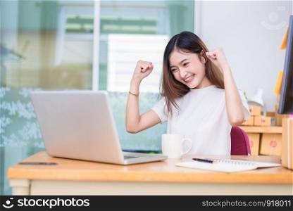Asian woman enjoy herself while using laptops and internet in office. Business and marketing and part time concept. On line shopping and business success theme. Happy mood when finished working job.
