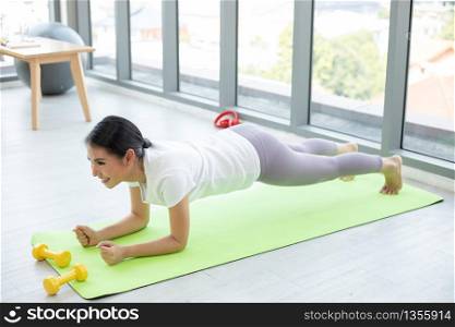 Asian woman exercising and planking at home