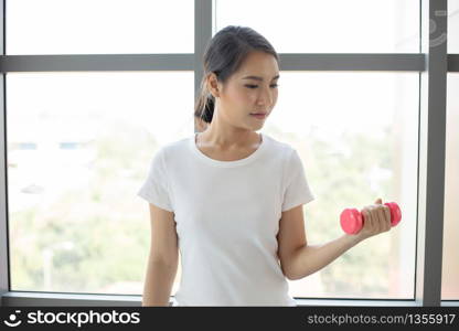 Asian woman exercising with dumbbell at home