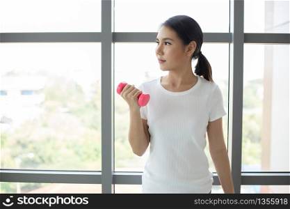 Asian woman exercising with dumbbell at home