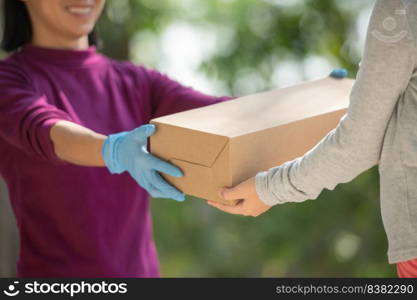 Asian woman from delivery service in purple t-shirt, portrait of delivery man holds cardboard box package standing with customer in front of door at home. home delivery shopping concept.
