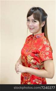 Asian woman greeting in traditional Chinese or cheongsam with hand lift welcome expression and lucky in chinese new year celebration in red golden style