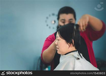 Asian woman hairdresser or hairstyle haircut a woman plump body customer in fashion hairstyle at barbershop. Hairstyle or barber haircut customer at barbershop