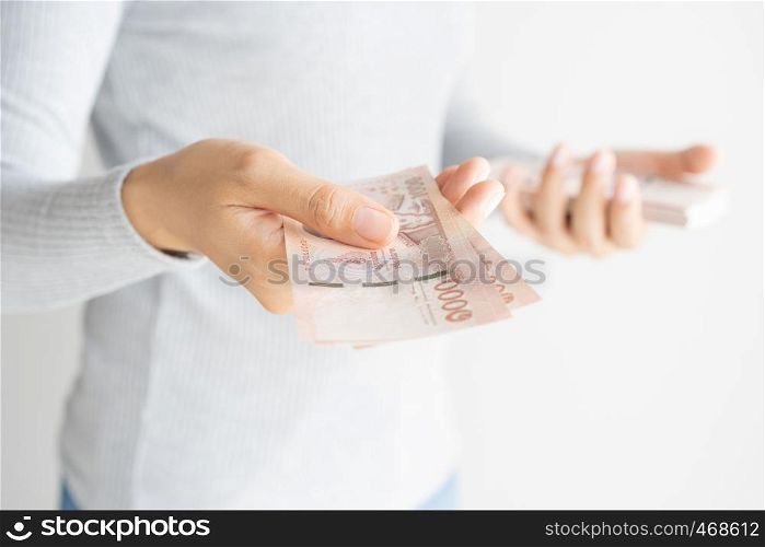 Asian woman hand counting money on white background. Money baht of thailand in her hand.