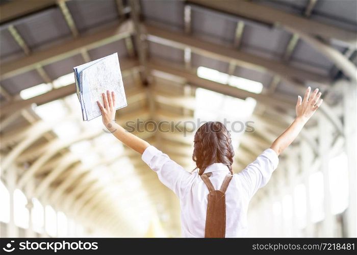 Asian woman Hands up hold the map at railway station travel,traveler with backpack in summer Holiday concept Thailand