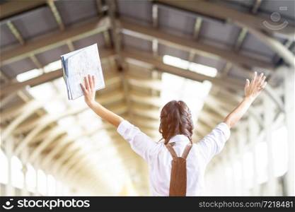 Asian woman Hands up hold the map at railway station travel,traveler with backpack in summer Holiday concept Thailand