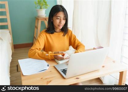 Asian woman learning online with a tutor via the internet with a laptop, Asia student girl video conference on a computer on a desk, Concept online learning at home