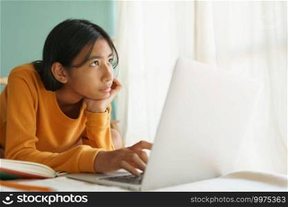 Asian woman learning online with a tutor via the internet with a laptop While looking outside the house in morning, Concept online learning at home