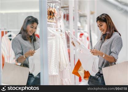 Asian woman looking and choosing the underwear in store shop with happy action at department center
